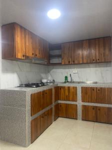 a kitchen with wooden cabinets and a counter top at La bendición de sunnyvale in La Vega +15 photos