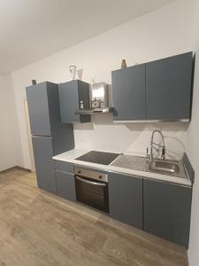 Una cocina con gabinetes grises y un fregadero. en Sidera, en Dervio