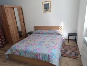 Un dormitorio con una cama con un edredón colorido. en Sidera Dafni, en Dervio