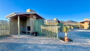 une maison avec une clôture en bois et un plancher en bois dans l'établissement Kroon Lodge, à Kamieskroon