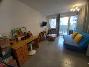 a living room with a blue couch and a desk at 100m lac et piste cyclable avec parking gratuit in Sévrier