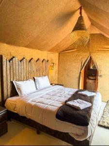 a bedroom with a bed in a tent at fabulousluxurycamp in Merzouga