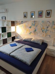 a bedroom with a bed with blue pillows on it at Apartman Centar Surcin in Surčin