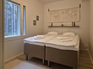 una camera da letto con un letto con asciugamani sopra di Villa Arvoranta a Nellimö