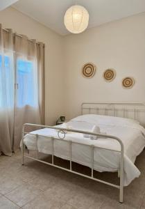 a white bed in a white room with a window at DownTown Apartment Konitsa in Konitsa