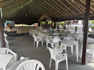 a group of white tables and chairs under an umbrella at Hotel Hot Springs 528 in Caldas Novas