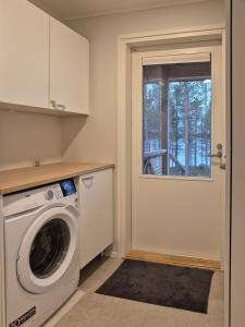 una lavanderia con lavatrice e finestra di Villa Arvoranta a Nellimö