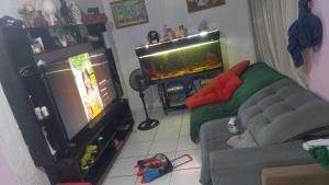 ein Wohnzimmer mit einem Sofa und einem Aquarium in der Unterkunft COP 30 Casa para grupos in Água Boa