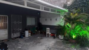 eine Terrasse mit Stühlen und einer Palme in einem Gebäude in der Unterkunft COP 30 Casa para grupos in Água Boa