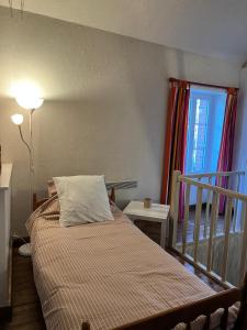 a bedroom with a bed and a window and a lamp at La maison bleue 