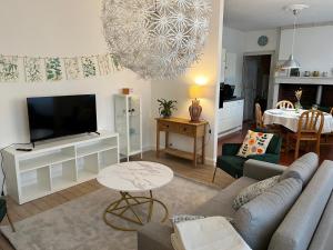 a living room with a couch and a flat screen tv at La maison bleue  +38 photos