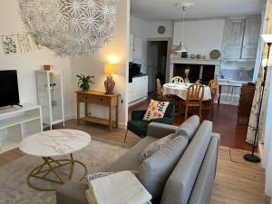 a living room with a couch and a table at Gîte La maison bleue proche Epernay in Chaltrait