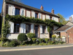 a house with ivy growing on the side of it at Gîte La maison bleue proche Epernay in Chaltrait