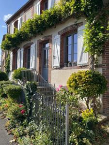 a house with a fence and flowers in front of it at La maison bleue 