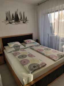a bed with two pillows on it in a bedroom at Borics Apartman in Balatonföldvár +22 photos