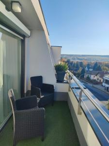 a balcony with chairs and a view of a street at Borics Apartman in Balatonföldvár