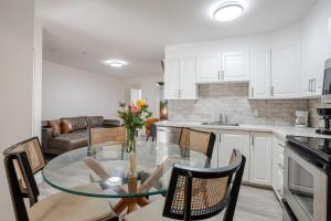 une cuisine et une salle à manger avec une table et des chaises en verre dans l'établissement Stylish 3BR in Montreal Village, à Montréal 25 autres photos