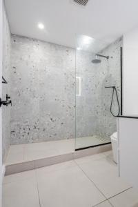 une salle de bain avec une douche avec une porte vitrée dans l'établissement Stylish 3BR in Montreal Village, à Montréal