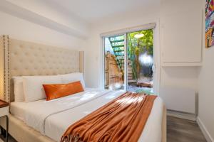 une chambre avec un lit et une grande fenêtre dans l'établissement Stylish 3BR in Montreal Village, à Montréal
