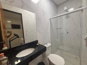 a bathroom with a toilet and a sink and a shower at Pousada Lua Bela in Piranhas