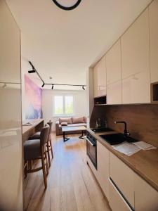 une cuisine avec des armoires blanches et un salon dans l'établissement Jahorina, Bosna i Hercegovina - Moja planina, à Trnovo