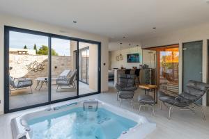 Una bañera de hidromasaje en una sala de estar con patio. en Suite romantique Zen Energie, en Volx