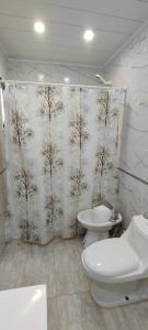 a bathroom with a shower curtain with trees on it at Antar Mouna in Cortaderas