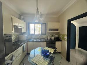a small kitchen with a glass table in it at Villa Nouryan l'Azur of Carthage in La Marsa