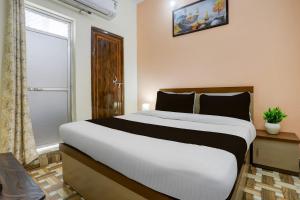 Un dormitorio con una cama blanca grande y una ventana en Hotel O Royal Stay Inn, en Kakarmatha