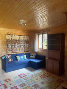 a blue couch in a room with a wooden ceiling at Les sapins in Eyne