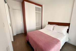 a bedroom with a bed with white sheets and a red blanket at Pet Friendly - apto completo Gleba Palhano in Londrina +19 photos