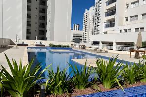 an image of a swimming pool with buildings in the background at Pet Friendly - apto completo Gleba Palhano in Londrina