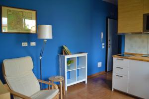 una cocina con paredes azules, una silla y una mesa en Piccola Suite Blu en Padova