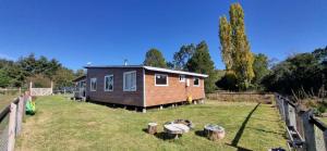 a tiny house in a yard with a fence at Cabaña Alto Puelo in Puelo