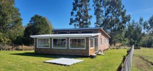 a small house in a field with a fence at Cabaña Alto Puelo in Puelo