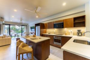 a kitchen with wooden cabinets and a living room at 3062 - Solana C203 in Cedro