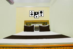 a bedroom with a large bed with black pillows at Hotel O Ansh Raj Hotel in Patna City