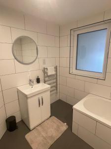 a bathroom with a sink and a tub and a mirror at The Owlery in Fort William +22 photos