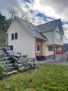 a white house with a stone wall at The Owlery in Fort William