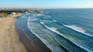 an aerial view of a beach with waves at Sea & City Escape in Matosinhos