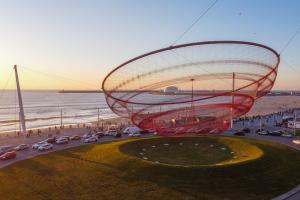 a large metal object in a parking lot next to the beach at Sea & City Escape in Matosinhos +8 photos
