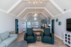 ein Wohnzimmer mit Sofa, Stühlen und einem Tisch in der Unterkunft Barefoot Bungalow in Edisto Island