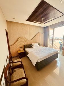 a bedroom with a bed and two chairs in it at MG Luxury Stays - Entire 4 BHK in Panchkula