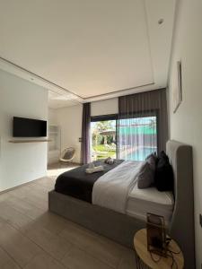 NajemVilla Prestige的一间卧室，配有一张大床和一扇大窗户。
