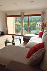 a living room with two beds and a large window at Apartamento en Montserrat- Montserrat Paradise Apartament in Monistrol