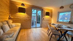 een woonkamer met een bank en een eettafel bij TheWoodenStack in Waldachtal