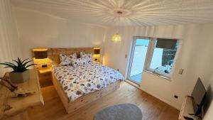 een slaapkamer met een bed en een groot raam bij TheWoodenStack in Waldachtal