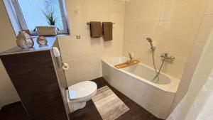 een badkamer met een bad, een toilet en een wastafel bij TheWoodenStack in Waldachtal +21 foto's