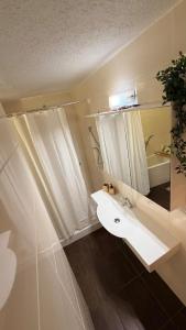 een witte badkamer met een wastafel en een spiegel bij TheWoodenStack in Waldachtal +19 foto's