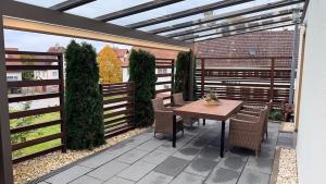 een patio met een houten tafel en stoelen bij TheWoodenStack in Waldachtal